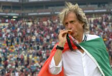 jorge jesus beija a medalha da libertadores coberto pela bandeira de portugal