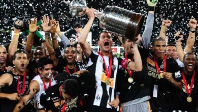 rever, capitao do atletico mineiro, ergue a taca da libertadores ao lado dos companheiros de equipe