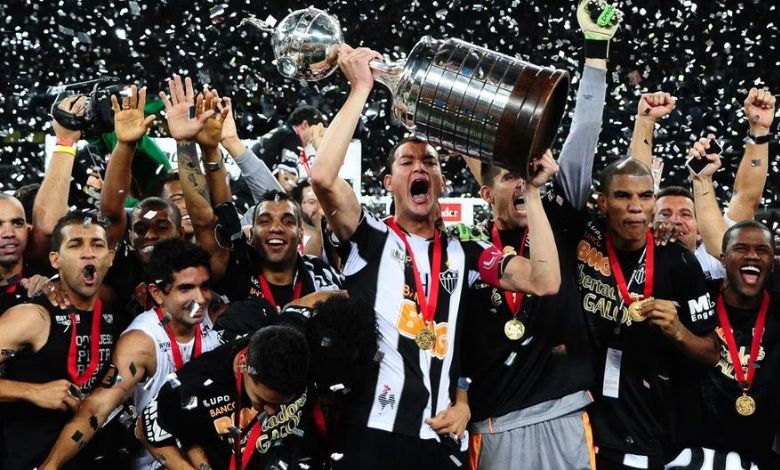 rever, capitao do atletico mineiro, ergue a taca da libertadores ao lado dos companheiros de equipe