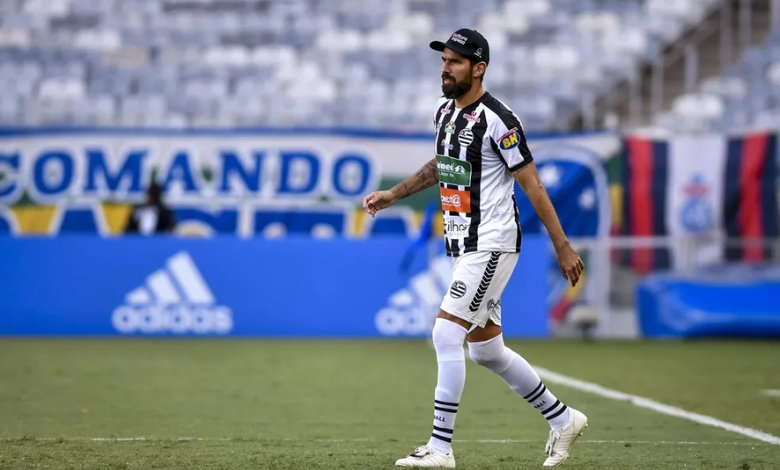 Loco Abreu, um atacante moreno, veste a camisa listrada de preto e branco do Athletic. Ele também está com um calção branco, além de meias e chuteiras brancas. Em seu fundo está uma bandeira branca, com a escrita Comando Rasta em letras azuis.