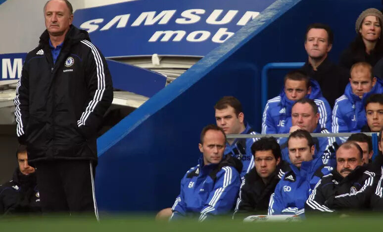 felipao com as maos no bolso da blusa ao lado do banco de reservas do chelsea comandando a equipe inglesa